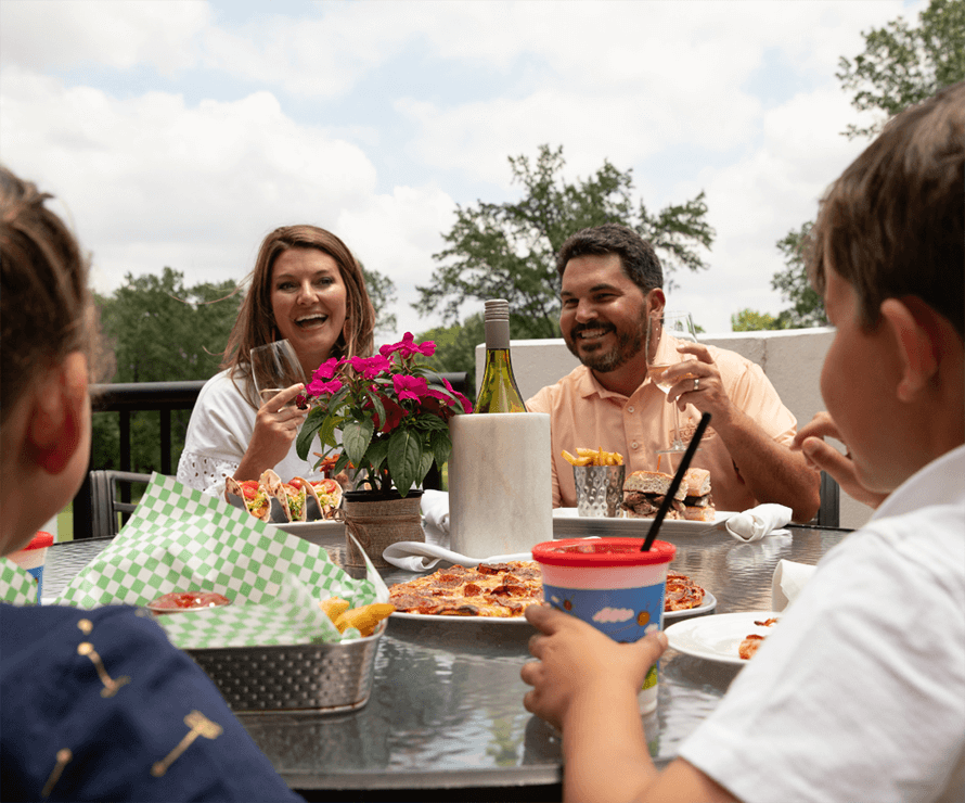 family seated at outside table